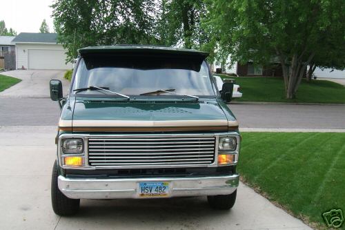 Green van with chrome grille and tan trim, parked in driveway. License plate HSV 482