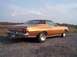 1975 Ford Torino - Gold 1975 Ford Torino coupe with a brown vinyl roof and aftermarket wheels parked on gravel.