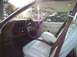 1975 Ford Torino - The interior of a classic car features a brown dashboard and white seats with brown seatbelts.