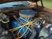1975 Ford Torino - The engine bay of a 1975 Ford Torino is visible, a blue V8 engine with a prominent air filter.