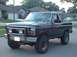 1985 Ford Bronco - driver front, nice dent, lost to a garbage dumpster's fence.