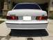 1995 Ford Taurus - Rear view of a white Ford Taurus SHO parked in a driveway, showing its distinctive taillights and badging.