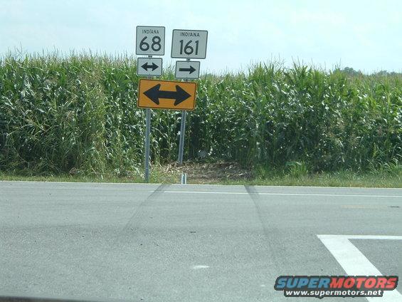 Roadside signs for Indiana 68 and 161 with a cornfield backdrop