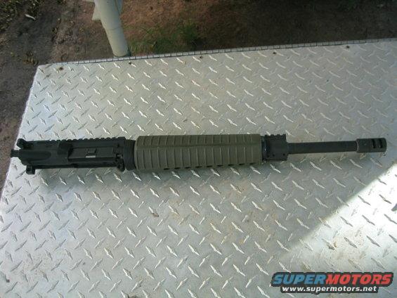 AR-15 upper receiver with green handguard and barrel assembly on diamond plate