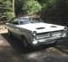 1973 Ford Ranchero - White 1966 Mercury Comet Cyclone coupe with a black roof and hood scoops is parked on a paved surface.