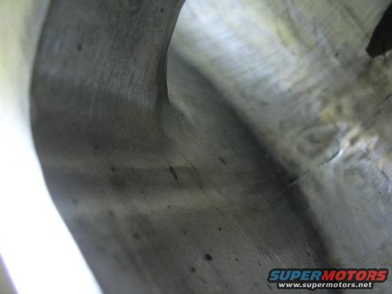 Close-up of an engine intake manifold with visible casting marks and some dark spots
