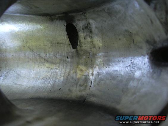 Interior of a metal intake manifold with a crack and an oval opening