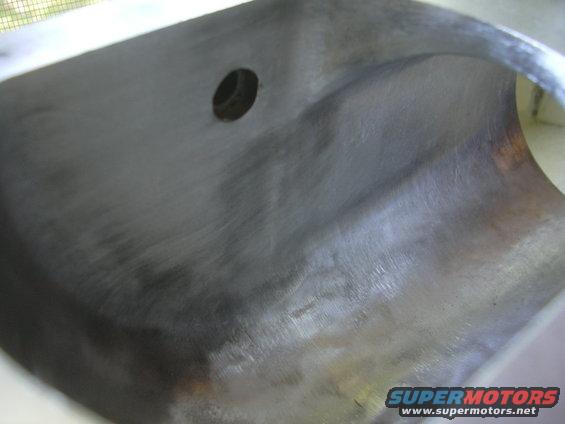 Close-up of a metal engine intake plenum with a circular opening