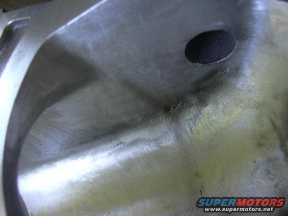 Close-up of a metal part with a circular hole and casting marks