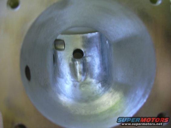 Inside view of a metal intake manifold with a central tube and two holes