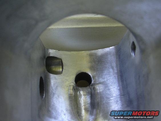 Aluminum intake plenum with circular and rectangular openings, showing casting marks and welds