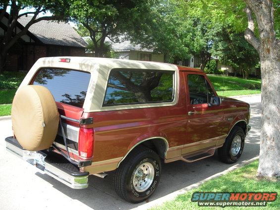 1995 Ford Bronco parked on a residential street, rear-mounted spare tire visible