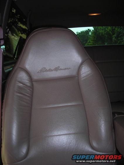 Brown leather car seat with "Eddie Bauer" script embroidered on the headrest