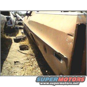 rusted car body panel with chrome trim, other car parts in background