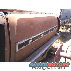 Side of old truck bed with 'FORD' emblem