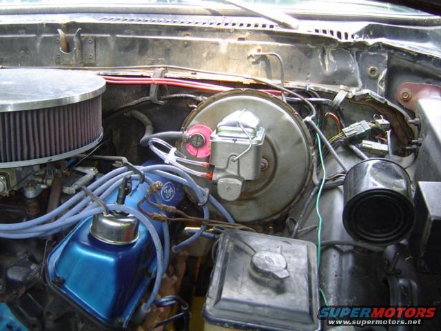 Engine bay with blue valve covers, large air filter, and brake booster