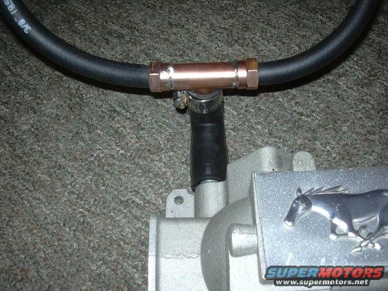 Close-up of a Ford Mustang intake manifold with a copper T-fitting and hose attached