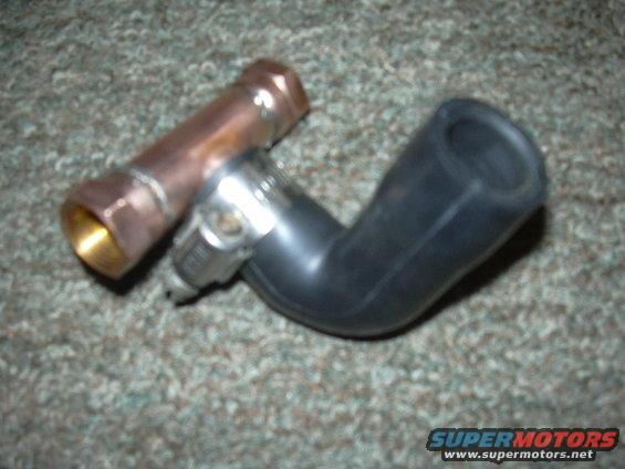Copper plenum fitting and black rubber hose part on carpet