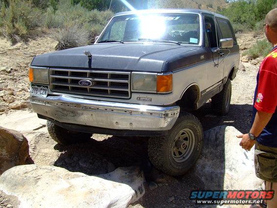 1987 Ford Bronco on rocks, two-tone paint, chrome bumper, license plate 378-CZN