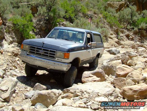 Two-tone 1987 Ford Bronco on a rocky off-road trail
