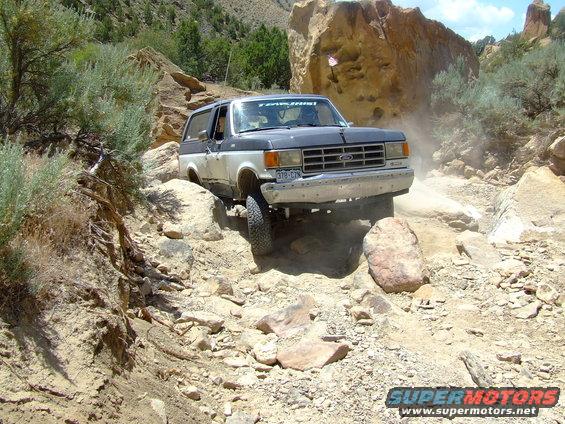 Ford Bronco navigating a rocky trail, kicking up dust