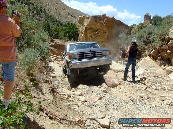 Gray 1987 Ford Bronco navigating a rocky off-road trail