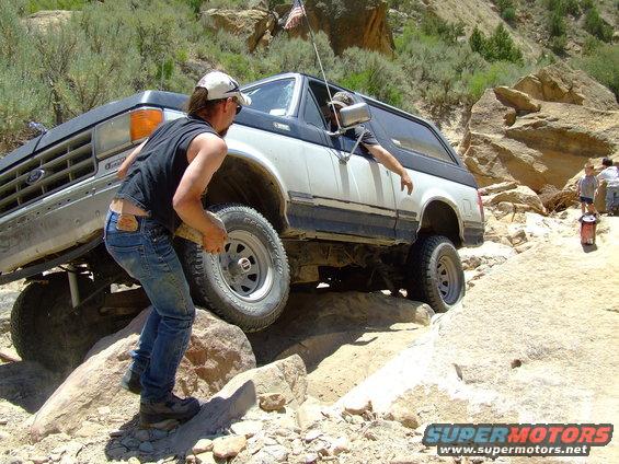 White and black Ford Bronco navigating rocky terrain