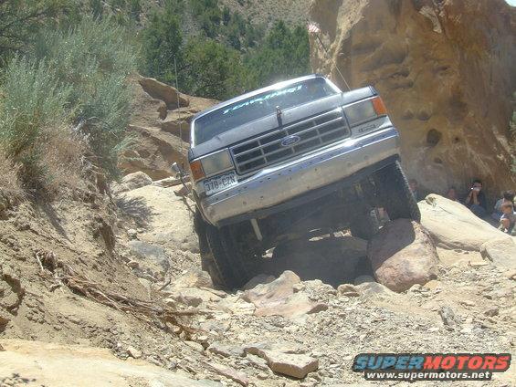 1987 Ford Bronco navigating a rocky trail, front grille visible