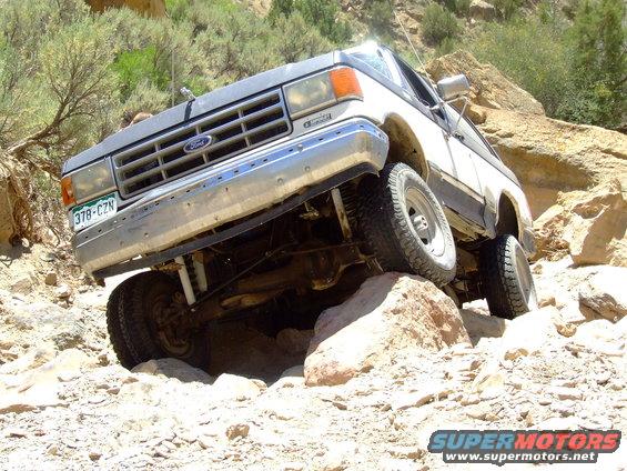 1987 Ford Bronco navigating rocky terrain, front grille visible