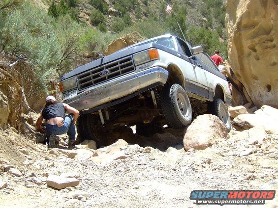 White and black Ford Bronco navigating rocky terrain