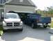 2004 Dodge Durango - Two Dodge vehicles, a Durango SUV and a Ram pickup, are parked in front of a suburban garage.