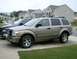 2004 Dodge Durango - This 2004 Dodge Durango is seen in a 3/4 front view, parked alongside a blue pickup truck.