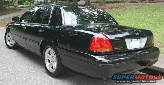 Black 2002 Ford Crown Victoria parked on a street, rear 3/4 view