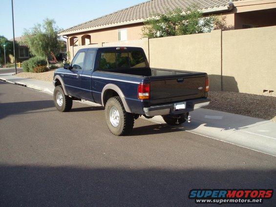 Blue pickup truck, rear view, lifted suspension