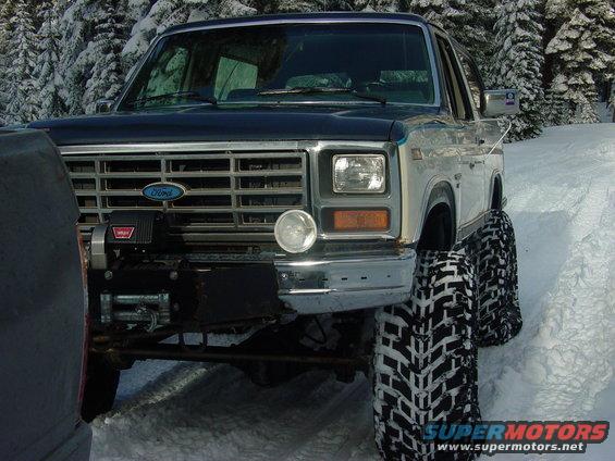 1986 Ford Bronco front with winch and large tires in snow