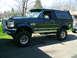 1993 Ford Bronco - This lifted 1993 Ford Bronco features a dark green exterior with chrome accents and custom wheels.