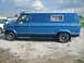 1978 Ford E250 - A blue 1978 Ford E250 van is parked outdoors next to another vehicle.