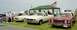 1976 Ford Ranchero - Several classic vehicles are displayed outdoors under a tent, with an American flag flying.