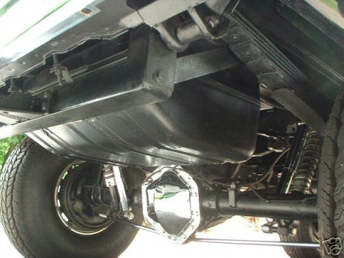 Underside of a vehicle showing a fuel tank, leaf springs, and rear axle with a chrome differential cover