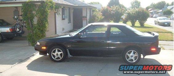 1989 Mazda MX-6 coupe parked in driveway, another car with a bike rack in the background