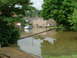 2001 Ford Fiesta - A silver hatchback is submerged in floodwaters on a residential street, with houses in the background.