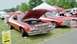 1976 Ford Ranchero - A red and white 1976 Ford Ranchero is displayed with its hood open at an outdoor event.
