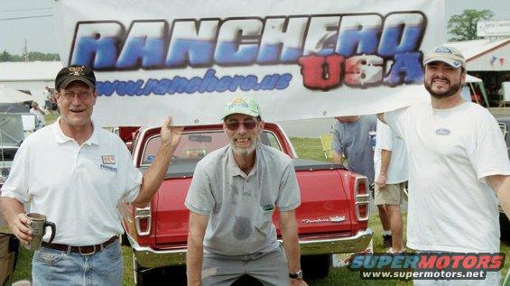 Three men hold up a banner that says "Ranchero USA" and has "www.ranchero.us" below it. A red vehicle is behind them