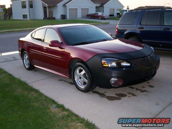 Red 2004 Pontiac Grand Prix with a black car bra parked on a driveway