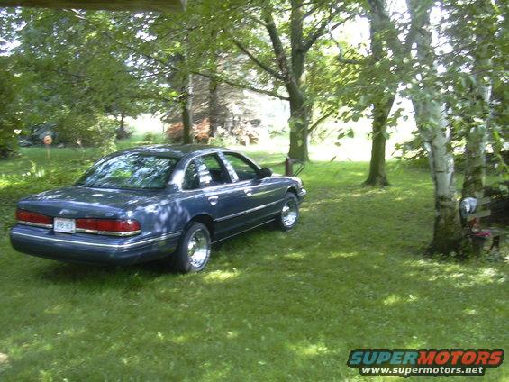 Blue 1996 Ford Crown Victoria parked in a grassy yard