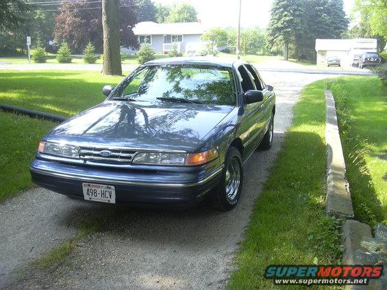 Blue sedan parked on a gravel driveway. License plate reads 498-HCV