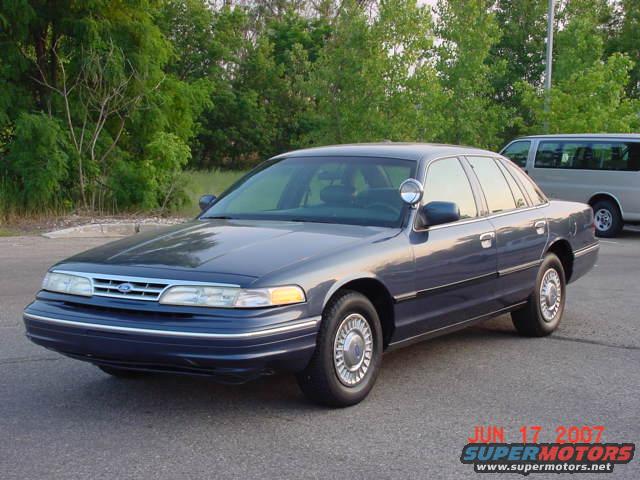 Blue 2003 Ford Crown Victoria with spotlight, 3/4 front view