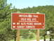 1996 Jeep Cherokee - A directional sign indicates routes to various locations in a wooded area, with a speed limit sign nearby.