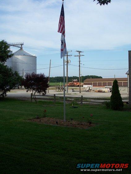 Scene with American and Illinois flags, grain silos, and farm buildings