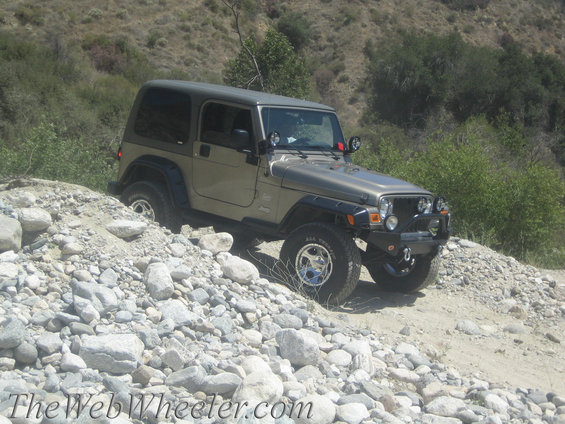 Tan Jeep Wrangler TJ on rocky terrain